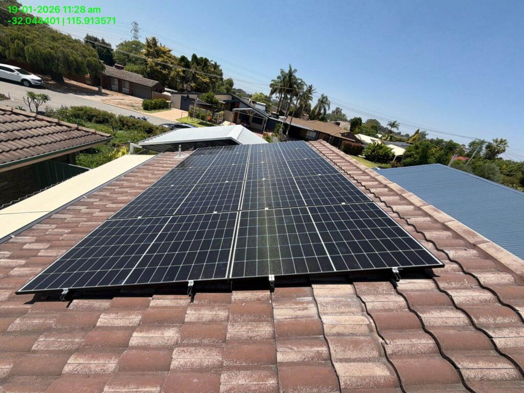 A 9.975kW solar system with 50.5kWh battery storage is installed on a tiled rooftop in Parkwood’s suburban neighbourhood under a clear blue sky, surrounded by trees and other houses. Date, time, and coordinates appear in green text at the top left corner.