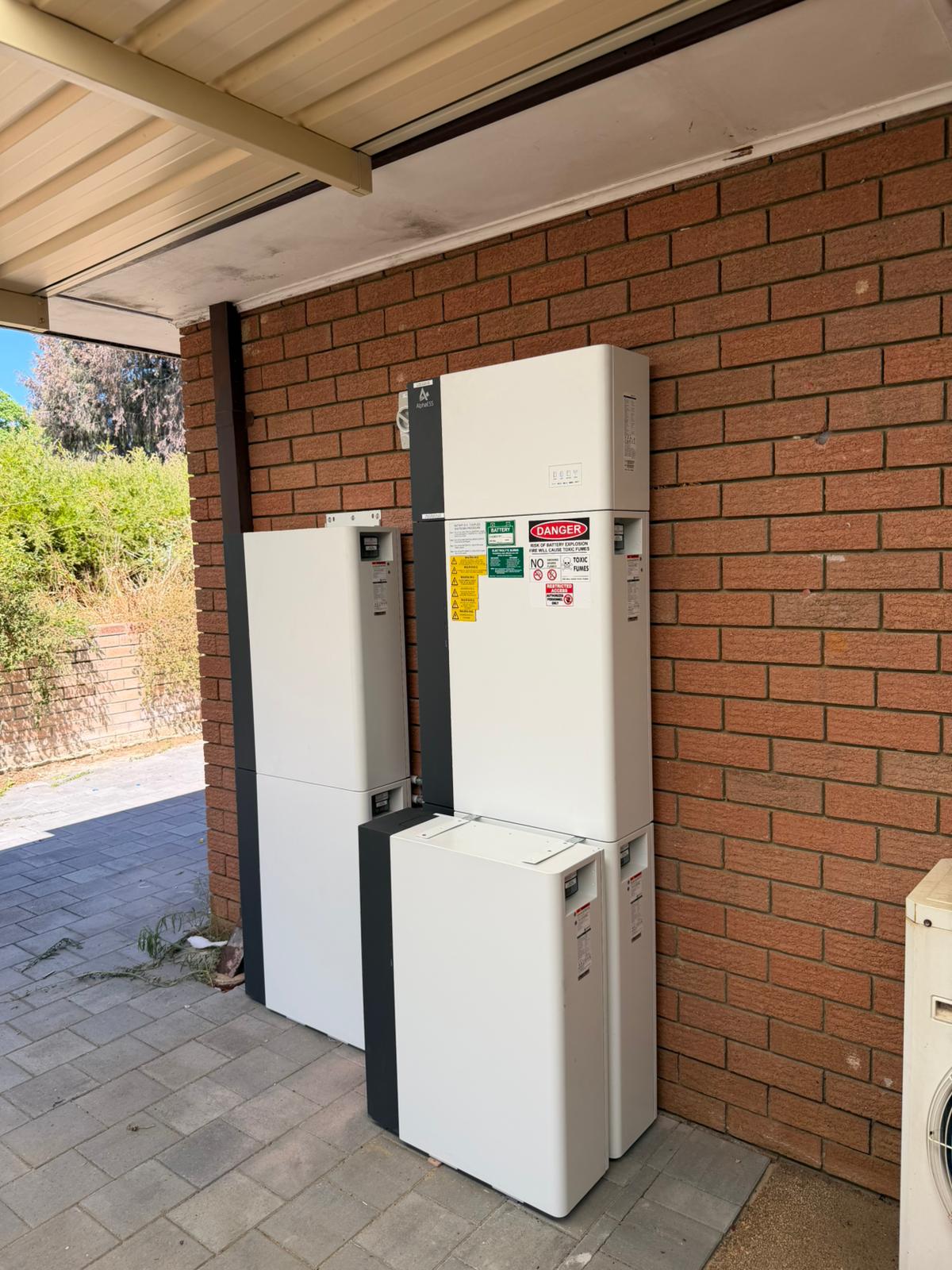 AlphaESS battery stack with safety signage in Kelmscott
