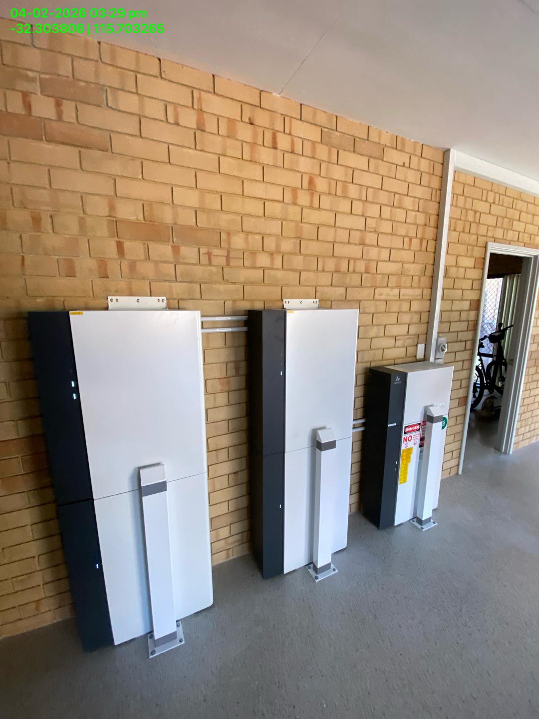 Two AlphaESS battery cabinets and inverter installed in a brick garage