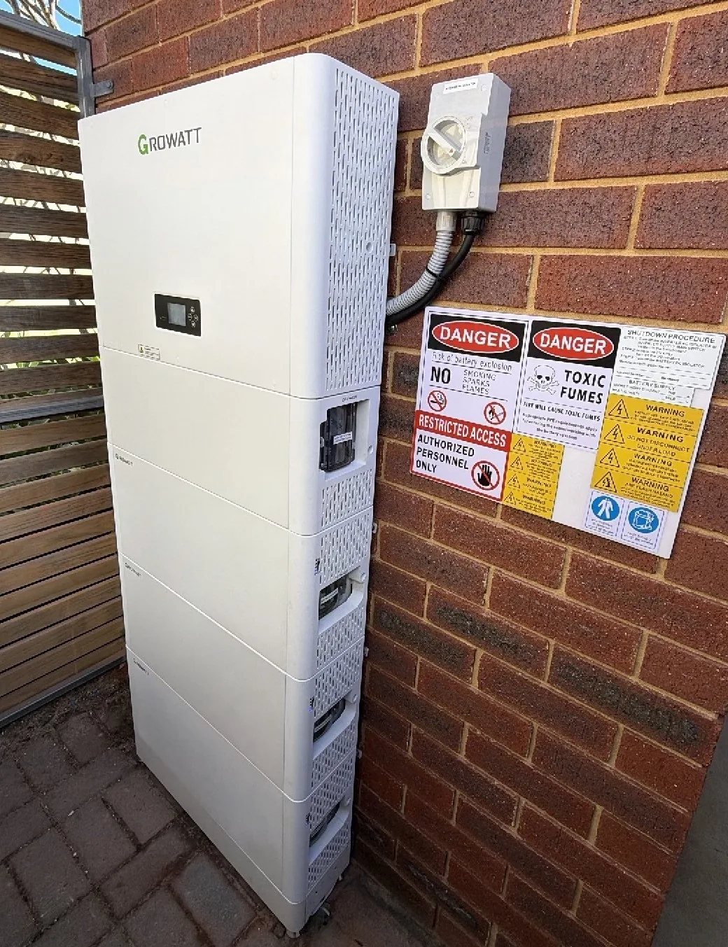 Growatt SPH inverter with three ALP battery modules against a brick wall