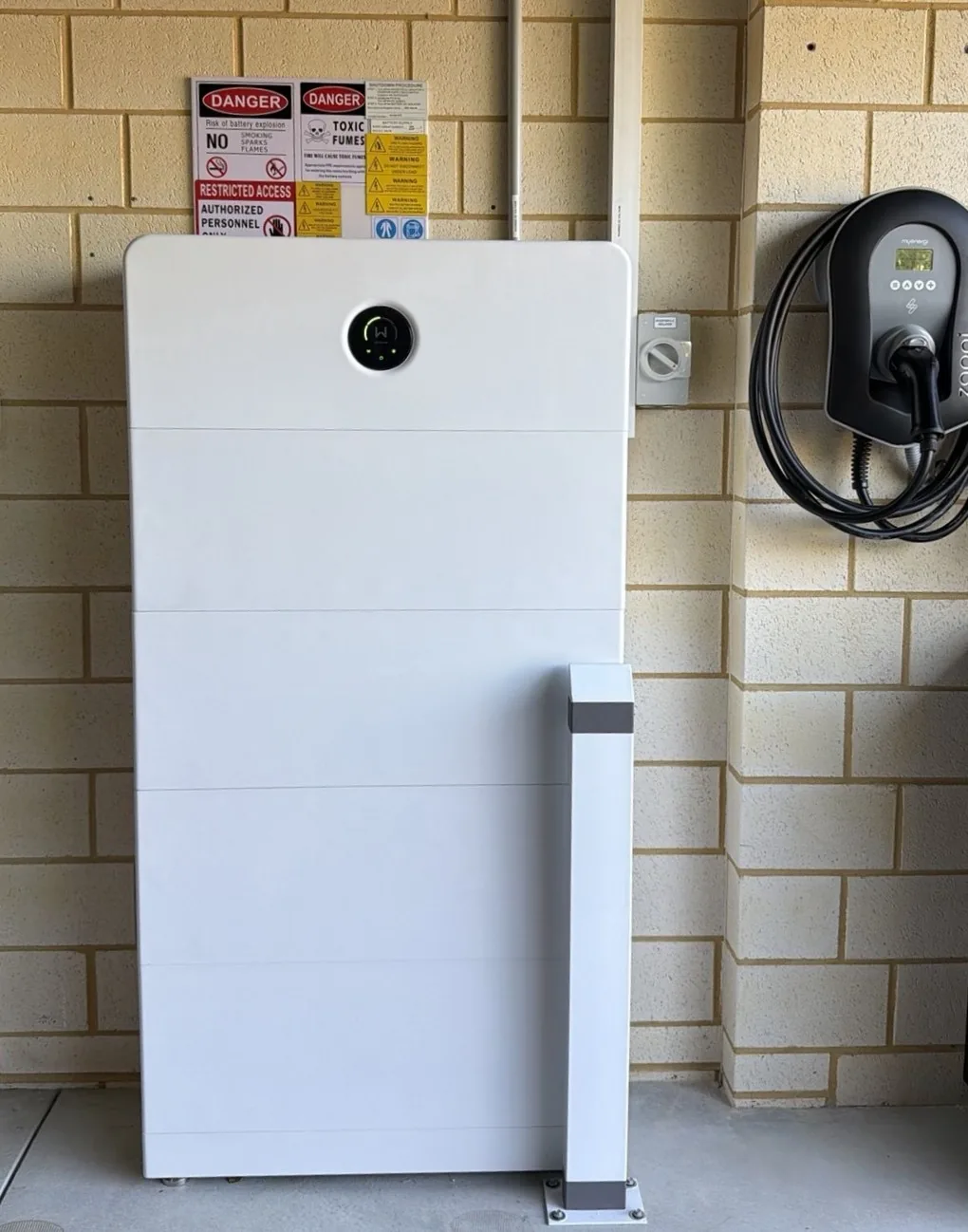 GoodWe ESA 33.28kWh battery with safety bollard next to a wall-mounted EV charger