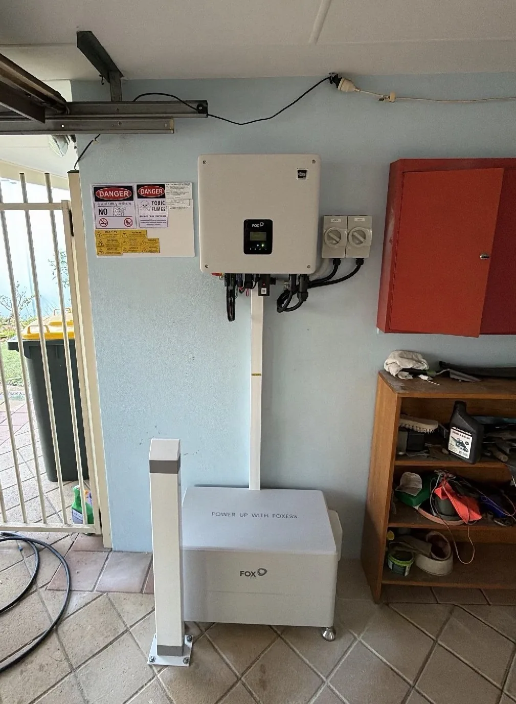 FoxESS H1 inverter mounted above a FoxESS battery in a covered outdoor area