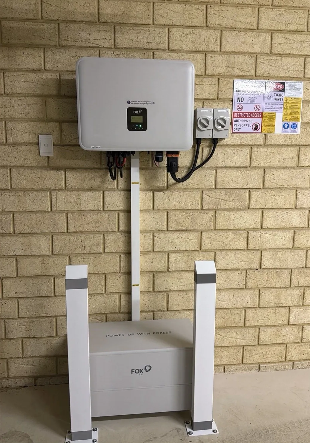 FoxESS H3 Smart inverter mounted above a FoxESS battery with two bollards