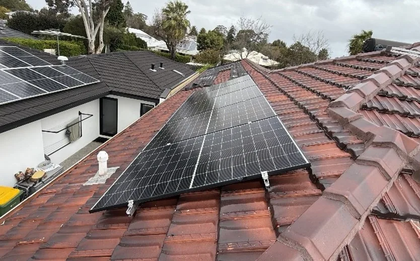 Trina solar panels on a terracotta tiled roof among mature trees in Floreat