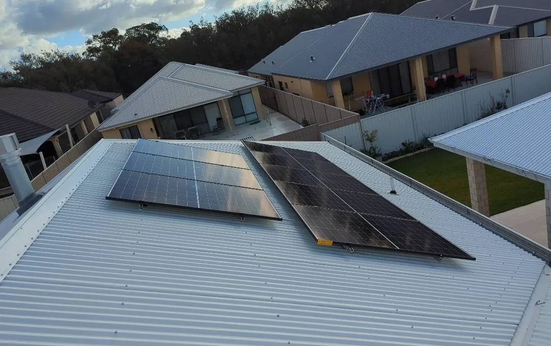 Solar panels on a light Colorbond roof in Madeley with bushland behind