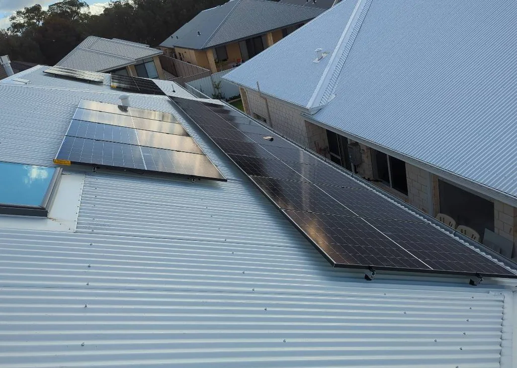 Two groups of solar panels beside a skylight on a Colorbond roof in Madeley