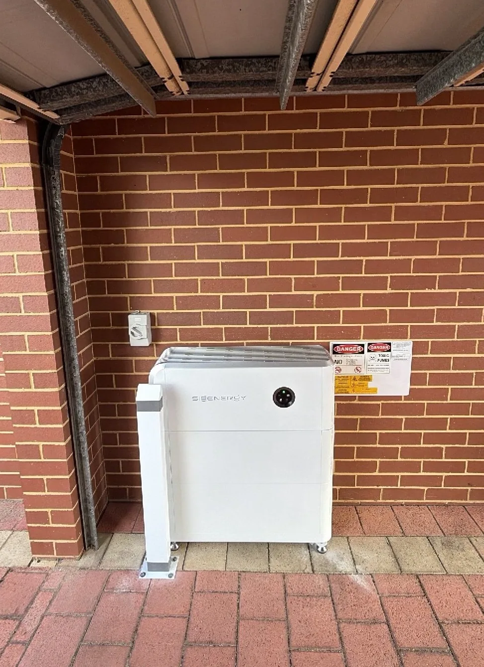 SigenStor 18.08kWh battery with bollard and isolator under a patio roof