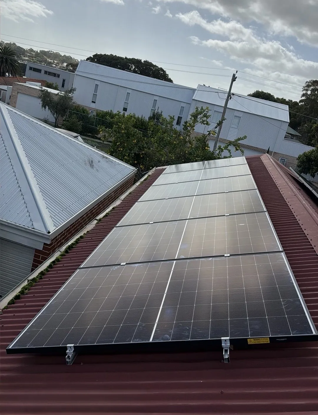 9.765kW of WINAICO NCX panels on a red roof in Palmyra
