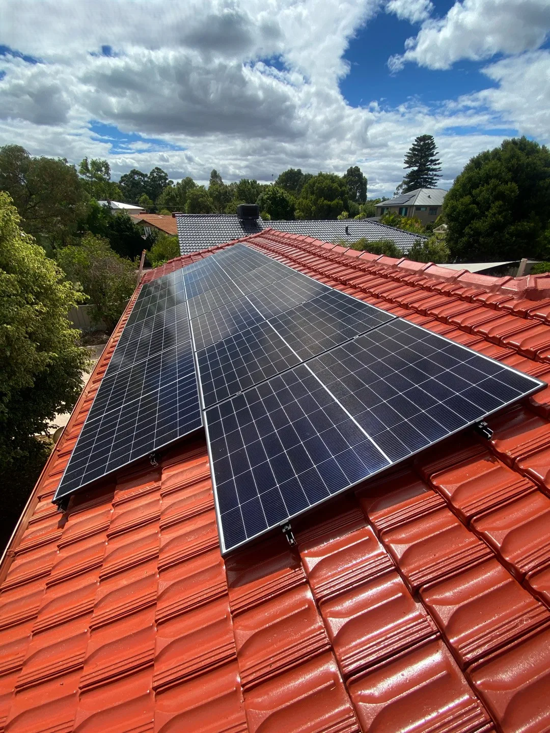 Long run of solar panels on a terracotta roof in Willetton
