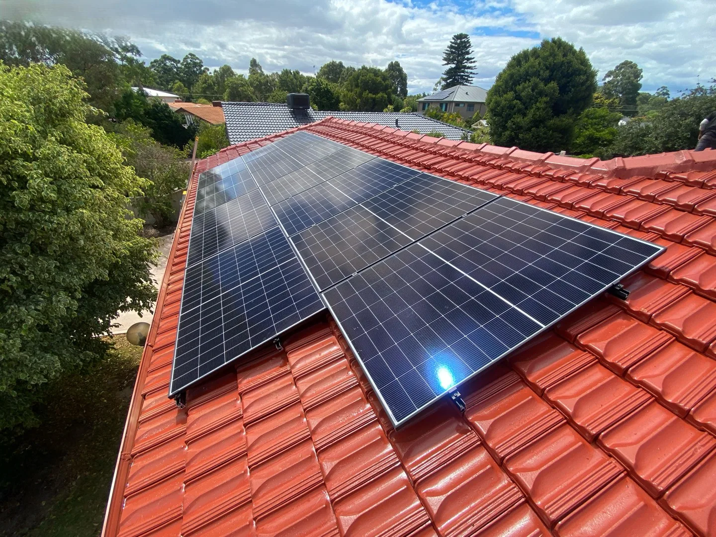 Solar panels on the rear roof of a Willetton home with trees behind