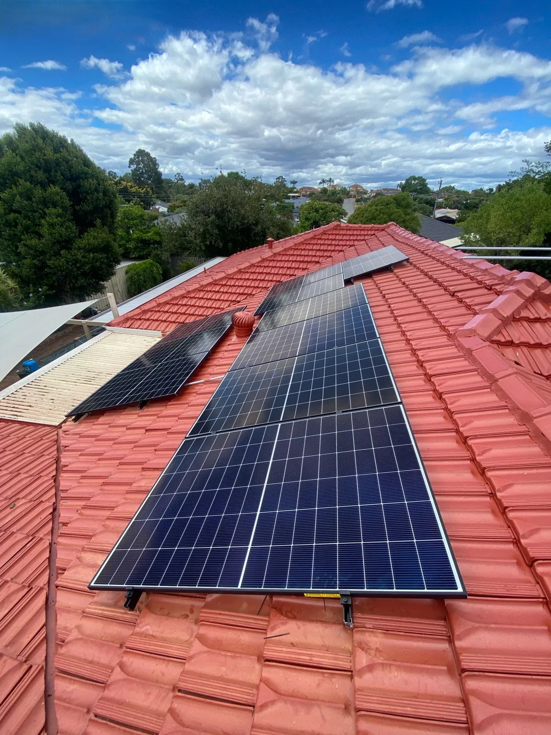 Solar panels stepping up toward the ridge of a tiled roof