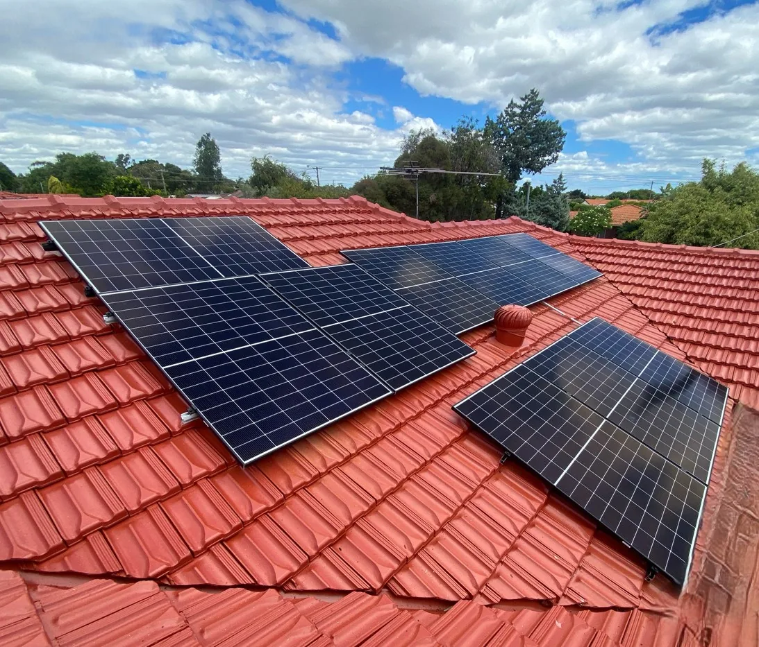 Solar panels fitted around a whirlybird on a red tiled roof